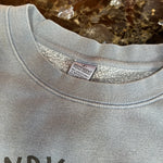 Gray sweatshirt with a brand label on a marble surface