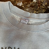 Gray sweatshirt with a brand label on a marble surface